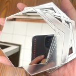 آینه دکوری آماتیس مدل لانه زنبوری 25 تکه - نمای نزدی و کیفیت آینه رو نشون میده که نایلون نازکی روشون هست که باید کنده بشه تا تمیز و شفاف بشن